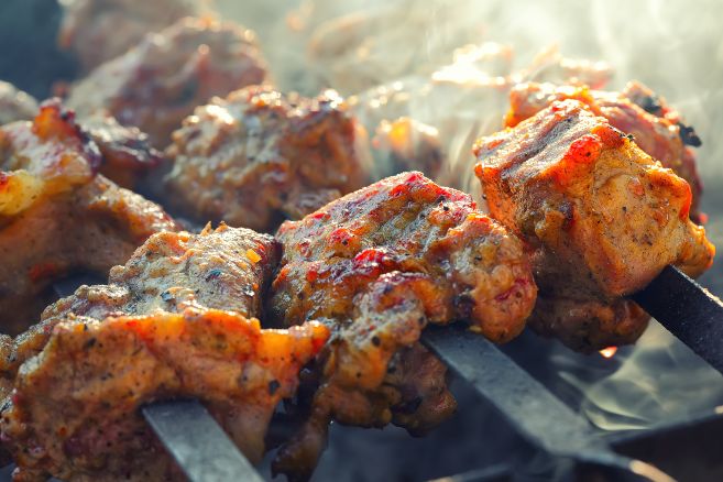 appetizing pieces of roasted meat on the fire. Smoky background