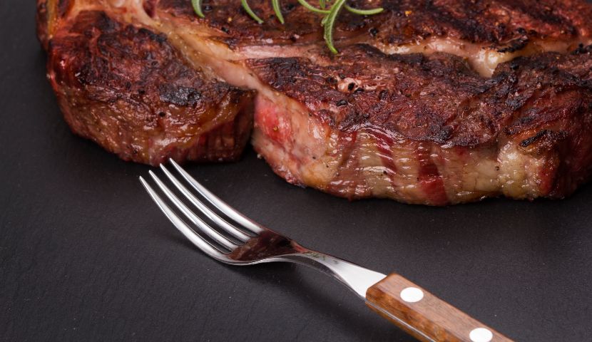 close-up view of medium-roast rib-eye stake on slate background